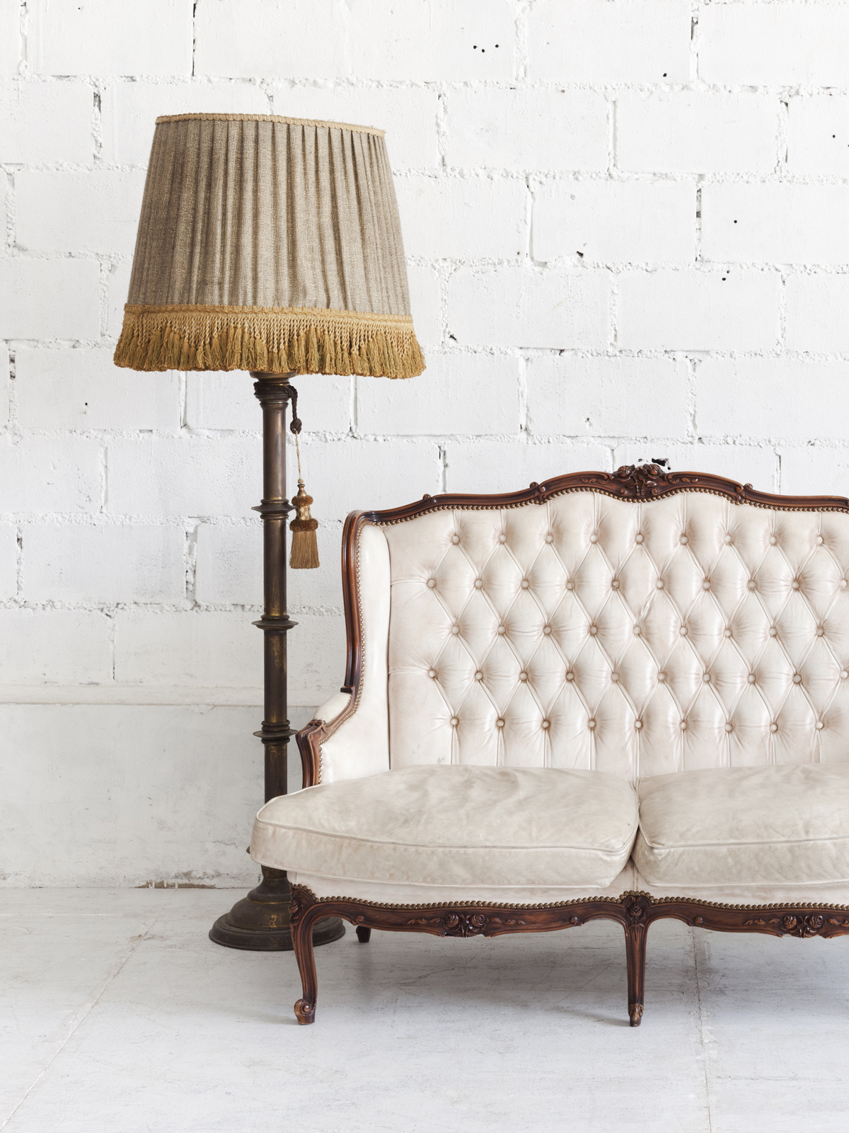 Antique white settee, lamp with fringed shade