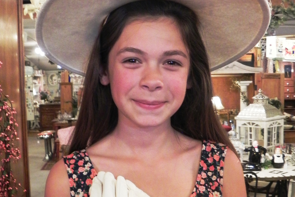 Lovely young lady tries on hat and gloves